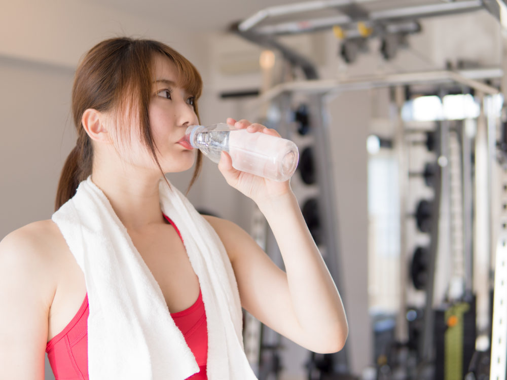 飲み物を飲むジムで身体を鍛える日本人女性