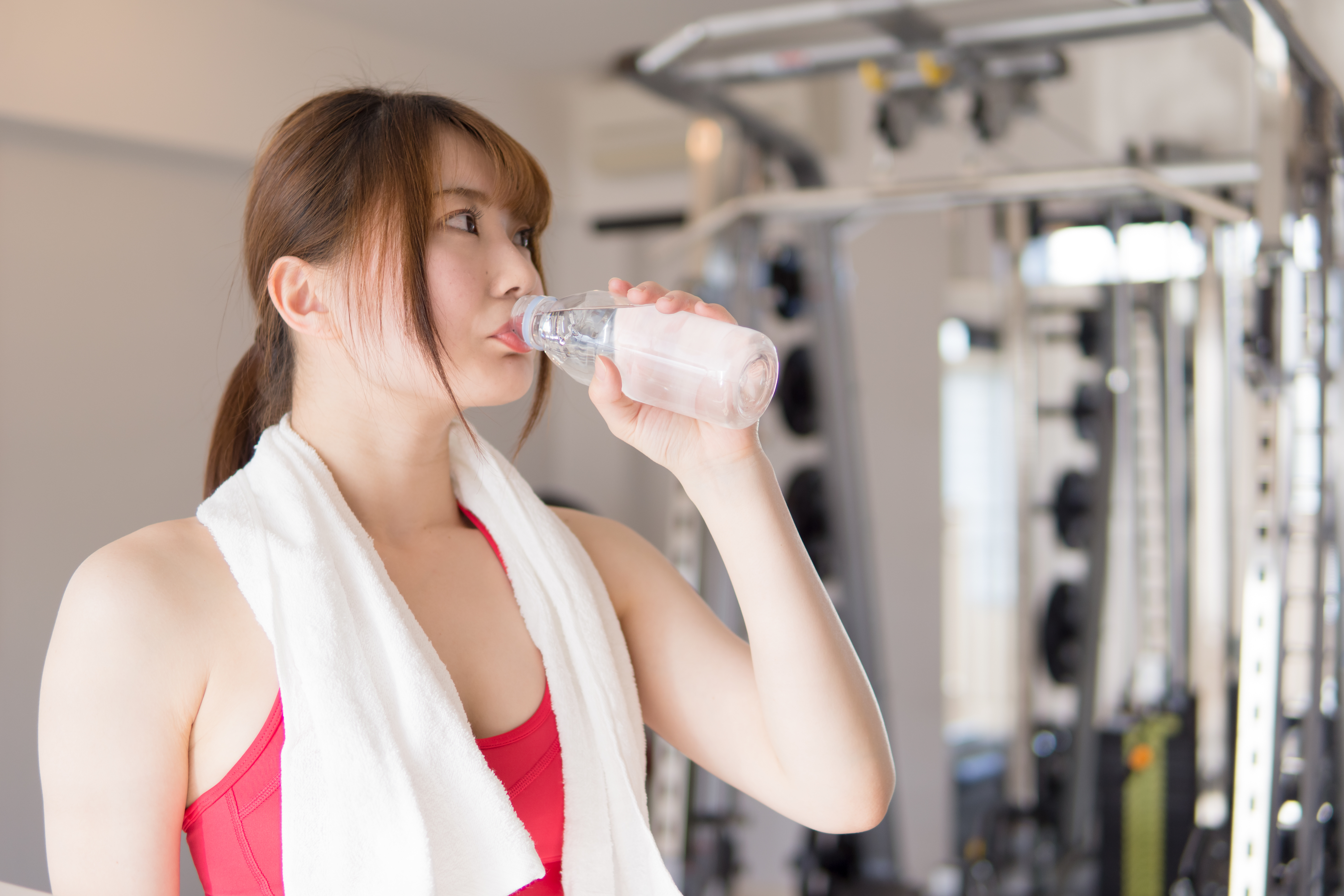 飲み物を飲むジムで身体を鍛える日本人女性